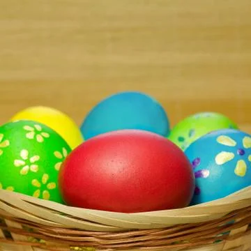 Colored  eggs in basket Stock Photos