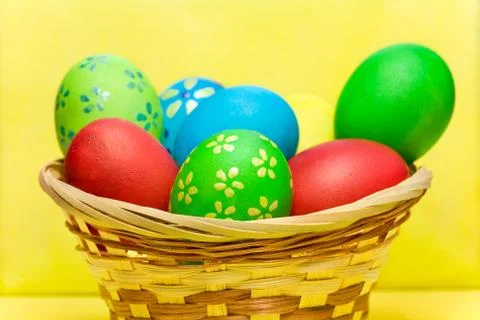 Colored  eggs in basket Stock Photos