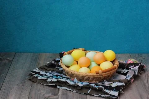 Colored eggs for Easter in a basket on table Stock Photos