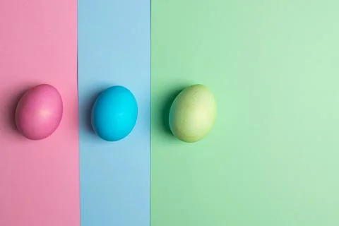 Colored eggs lie on three colored backgrounds Stock Photos