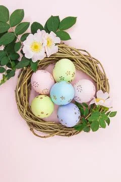Colored eggs in nest of branches with cherry or apricot branch Foto stock