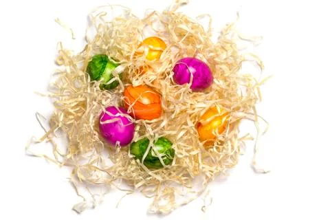 Colored eggs on packing straw. Isolated. Easter 2018. Top view Stock Photos