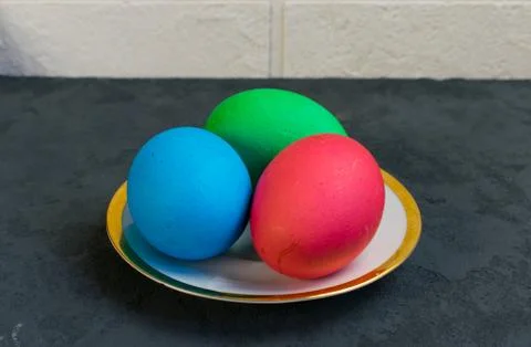 Colored eggs in a plate on the table, Easter is coming Stock Photos