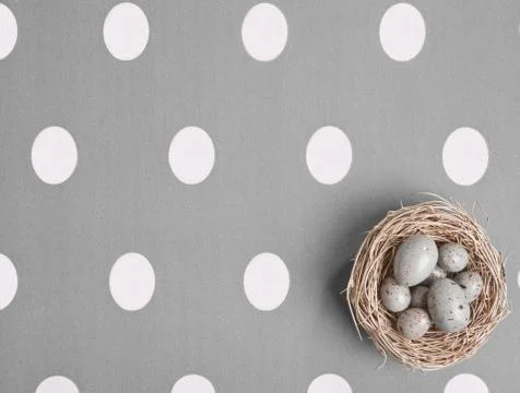 Colored eggs in a small nest Stock Photos