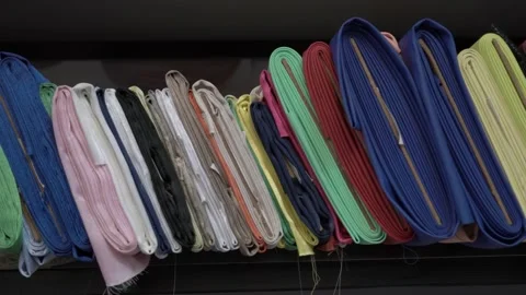 Colored fabrics in rolls on store shelves Video stock 169727592