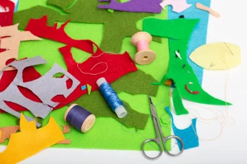 Colored felt, thread, needles and scissors on the table Stock Photos