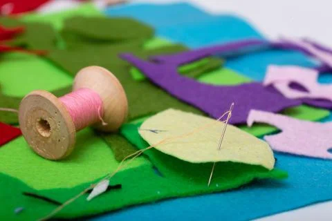 Colored felt, thread, needles and scissors on the table Stock Photos