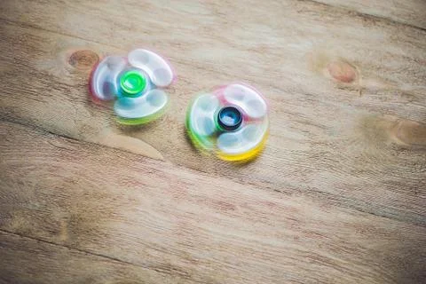 Colored fidget spinners stress relieving toy on wooden background Stock Photos