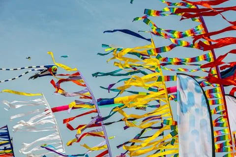 Colored flags against the blue sky with white clouds on holidays Foto stock