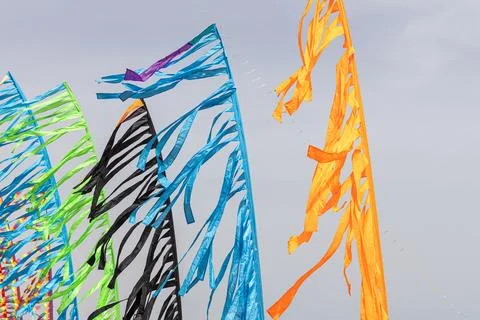 Colored flags against the blue sky with white clouds on holidays Stock Photos