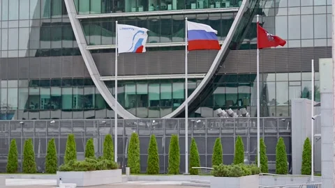 Colored flags flutterring on background of glass building on city street on Stock Footage 157231785