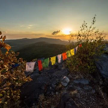 Colored flags on top of a mountain at sunset Stock Photos