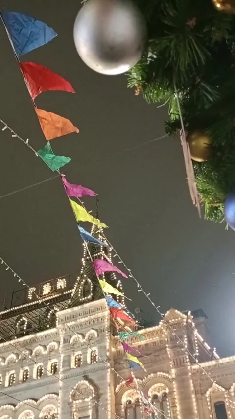 Colored flags in the wind, a garland of light bulbs and Christmas tree balls Stock Footage 298202563