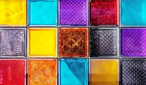 Colored glass blocks with embossed patterns. Multi-colored glass squares. Stock Photos