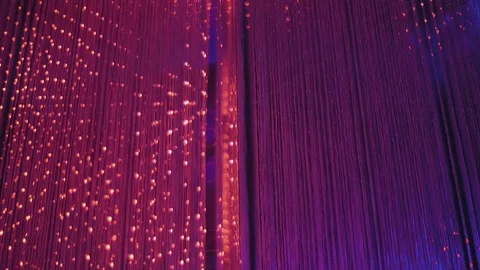 Colored glow of thousands of LEDs in hanging strips with flashes and fading Stock Footage 323852708