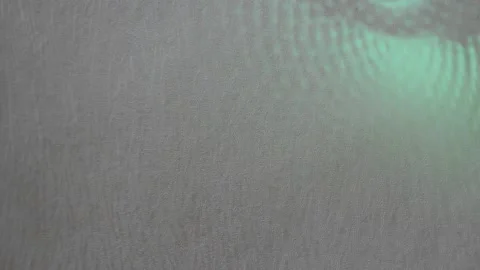 Colored green ray creeps along the gray wall Stock Footage 140015960