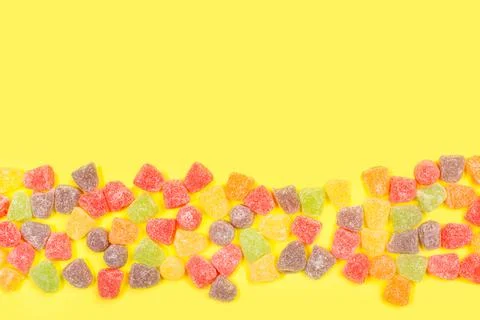 Colored gummies on a yellow background with copy space Stock Photos