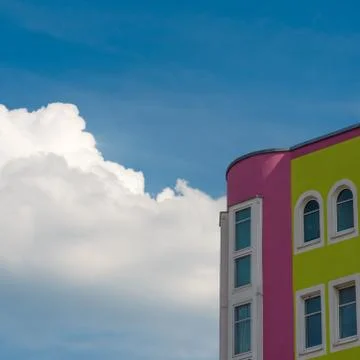 A colored house with a cloud in the background Stock Photos