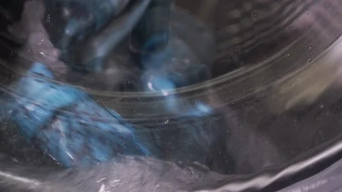 Colored items are washed in a washing machine, the drum with water and dete.. Stock Footage 315065494