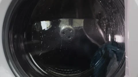 Colored items are washed in a washing machine, the drum with water and dete.. Stock Footage 342056593