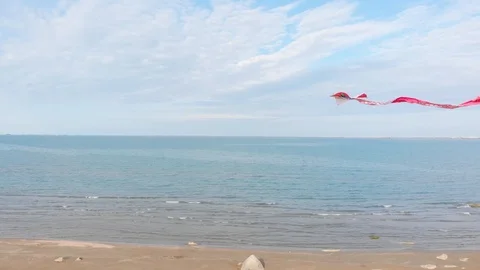 A colored kite in the blue sky. Shooting of a kite developing against a blue sky Stock Footage 127357600