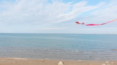 A colored kite in the blue sky. Shooting of a kite developing against a blue sky Stock Footage 127357631