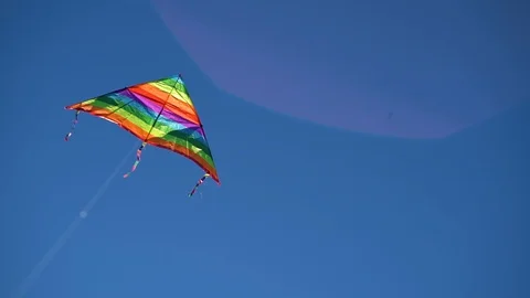 A colored kite in the blue sky. Slowed-down shooting of a kite developing Video stock 101280820