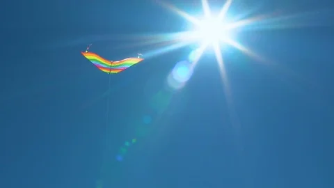 A colored kite in the blue sky. Slowed-down shooting of a kite developing Stock-Footage 101280915