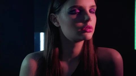 Colored light portrait woman posing red neon glow Stock Footage 125910074