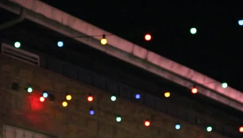 Colored lights hanging in courtyard Stock Footage 6897194