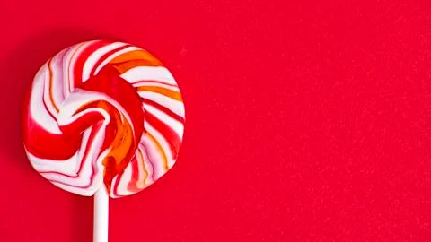 Colored lollipop on a red background close-up. Stock Photos