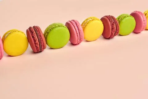 Colored macaron or macaroon, sweet meringue-based confection on pink background Fotos Stock
