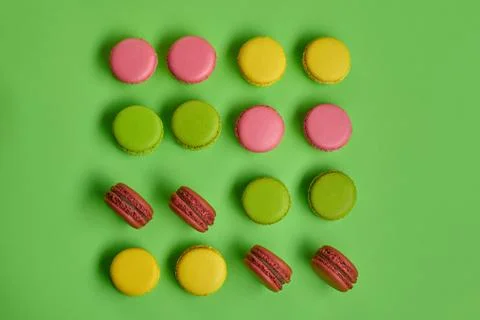 Colored macaron or macaroon, sweet meringue-based confection on green background Fotos Stock