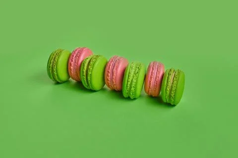 Colored macaron or macaroon, sweet meringue-based confection on green background Fotos Stock
