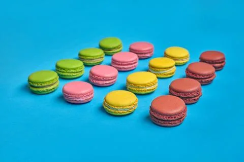 Colored macaron or macaroon, sweet meringue-based confection on blue background Fotos Stock