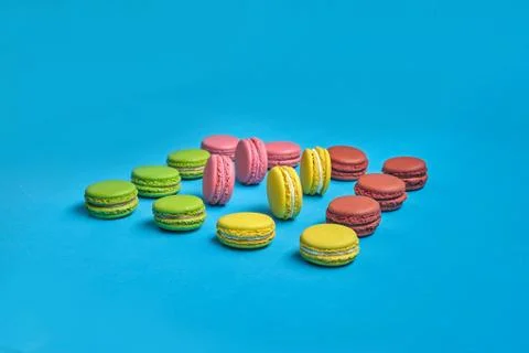 Colored macaron or macaroon, sweet meringue-based confection on blue background Fotos Stock