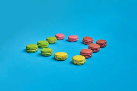 Colored macaron or macaroon, sweet meringue-based confection on blue background Fotos Stock