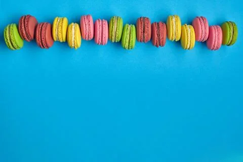 Colored macaron or macaroon, sweet meringue-based confection on blue background Fotos Stock