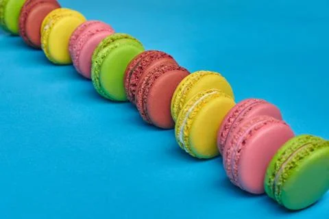 Colored macaron or macaroon, sweet meringue-based confection on blue background Fotos Stock