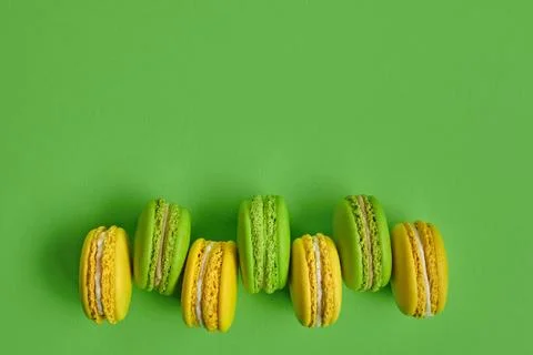 Colored macaron or macaroon, sweet meringue-based confection on green back... Fotos Stock