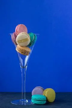 Colored macaroons in cup on blue background Stock Photos