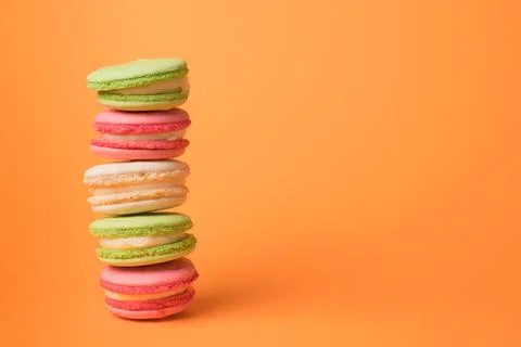 Colored macaroons row on orange background. Foto stock