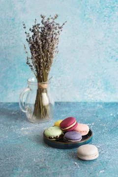 Colored macaroons on turquoise background and bouquet of lavender on background Stock Photos