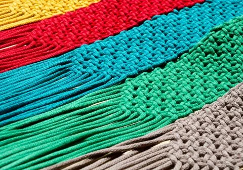 Colored macrame stripes in blue, yellow, red, beige, green and pink colors. Stock Photos