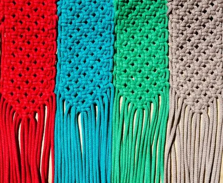 Colored macrame stripes in blue, yellow, red, beige, green and pink colors. Stock Photos