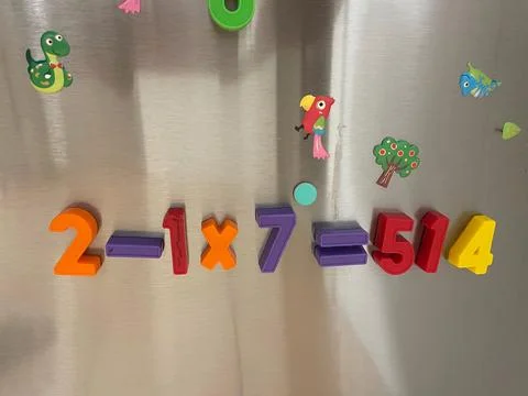 Colored magnetic numbers and mathematical symbols on a refrigerator door Foto stock