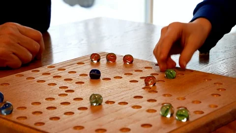 Colored marbles and dice are used to play a family game on a homemade board. Stock Footage 105687647