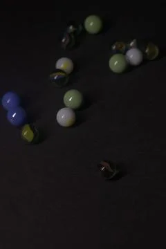 Colored marbles on a black background Stock Photos