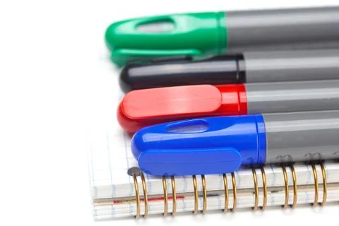 Colored markers and a notebook isolated on white Stock Photos