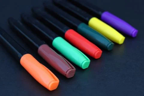 Colored markers on a black background Fotos de archivo